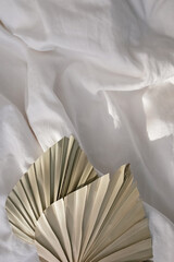 Dried palm leaf on white bed with copy space