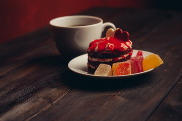Round red cake on a plate marmalade sweets dessert wooden table