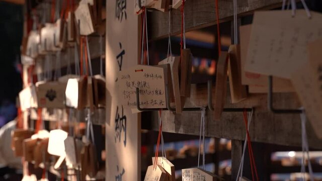 Slow Motion close up rotating shot of wooden wishing cards at Japanese Shrine