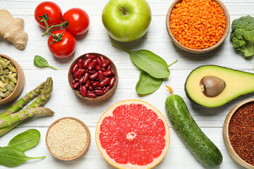 Different vegetables, seeds and fruits on white wooden table, flat lay. Healthy diet