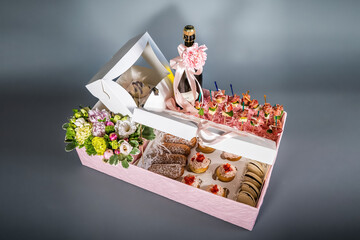top view of gift boxes and delicious candies, snacks, sweets, wine and chocolate pieces on black.