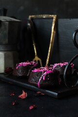 kleiner Browniekuchen mit pink Zuckerglaur,  getrockneten Rosenblüten und Zuckerperlen