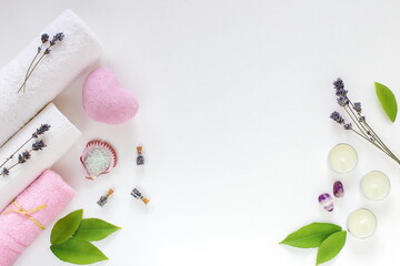 Spa cosmetics and towels, dry lavender, aroma oils and sea salt on a white background