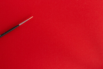 Black pen, pencil and brush on red background
