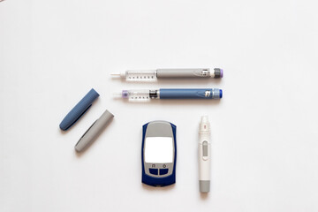Insulin short, long, glucose meter, test strips and finger piercing pen on a white isolated background. Set for diabetics with mock up