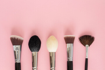 Set of large cosmetic brushes on pink background