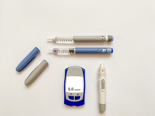 Insulin short, long, glucose meter, test strips and finger piercing pen on a white isolated...