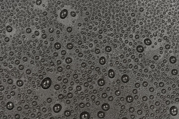 Water drops on black background texture. Dark backdrop glass covered with drops of water. gray bubbles in water