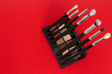 Set of small cosmetic brushes on red background
