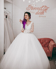 beautiful bride with purple hair picks up her wedding dress