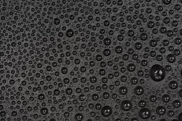 Water drops on black background texture. Dark backdrop glass covered with drops of water. gray bubbles in water