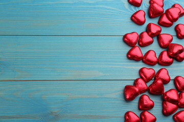 Heart shaped chocolate candies on blue wooden table, flat lay with space for text. Valentines's day celebration
