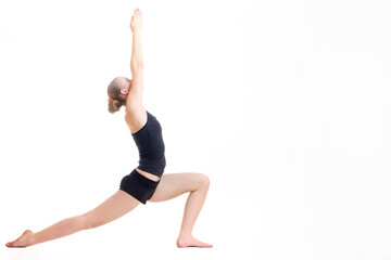 young blond hair woman in yoga pose virabhadrasana or the warrior pose
