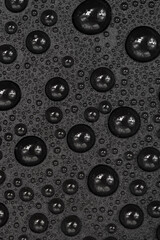 Water drops on black background texture. Dark backdrop glass covered with drops of water. gray bubbles in water