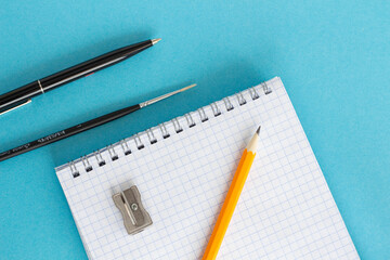 Student concept. Pen, notebook, pencil on a blue background