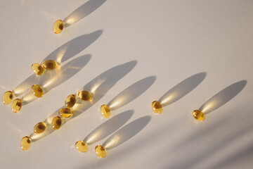 Capsules with vitamin D on the white table