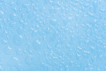 Water drops on blue background texture. Backdrop glass covered with drops of water. bubbles in water