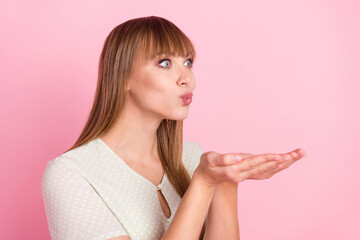 Profile side view portrait of attractive cheerful funny girl sending air kiss amour isolated over pink pastel color background