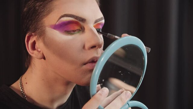 Drag artist - young man applying black eyeliner