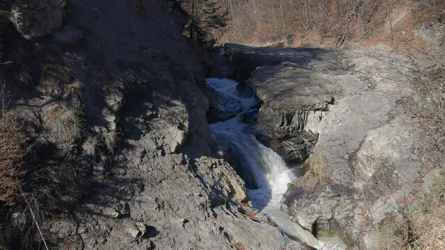 Small waterfall, in rocky nature, sunny fall day, Lepsa, Romania - static view