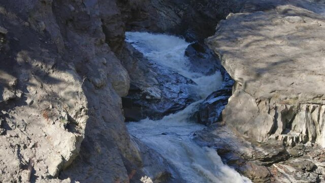 Flowing waterfall, in a rocky gorge, sunny fall day, Lepsa, Romania - still shot