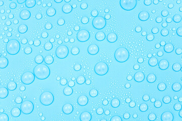 Water drops on blue background texture. Backdrop glass covered with drops of water. bubbles in water