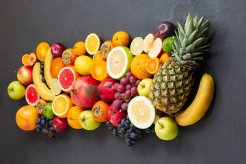 Naklejka na ściany i meble various tropical fruits on black background, top view