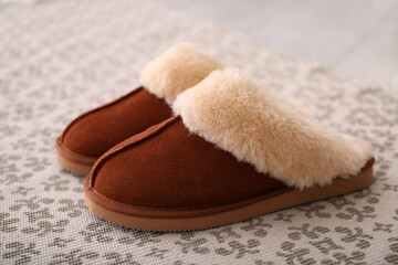 Brown warm slippers on floor in room