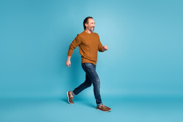 Fototapeta na wymiar Full length body size photo middle-aged bearded man smiling stepping hurrying in stylish clothes isolated on bright blue color background