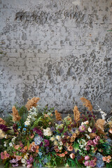 Composition of flowers against the background of a gray wall. Floristics in the design of the room. Dry flowers