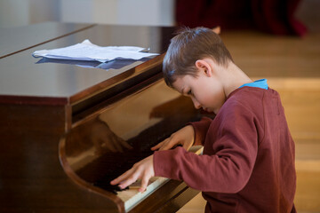 Fototapeta na wymiar Kid playing the piano at lesson and event. Kids back to school concept.