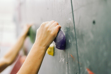 Close up photo of a rock climbing wall with climbing holds in gym