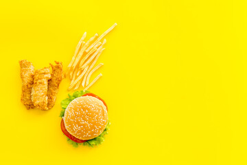 Fast food flat lay set. Burger with fried potatoes and chicken, top view