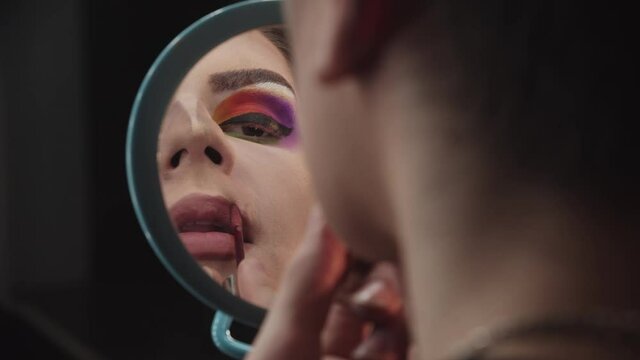 Drag artist - young man applying nude liquid lipstick