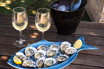 Raw oyster dish with lemon with champagne glasses