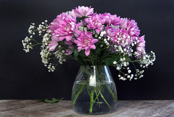 chrysanthemums in a vase on the table black background