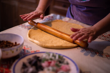 the housewife spreading the dough with a rolling pin. preparation of homemade cakes