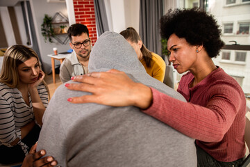 Diverse group of people sitting in circle in group therapy session.
