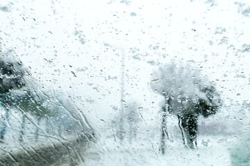 View from the car window on the snow-covered track. Road view through car window during snowfall. Selective focus.