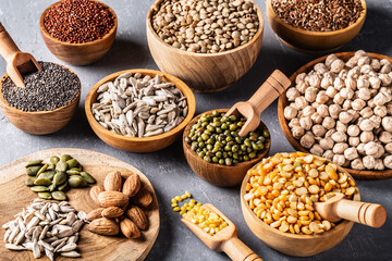 Assortment of beans, legumes on grey concrete background.