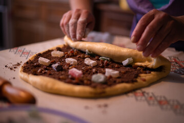 adding fillings to the cake as turkis delights, cocoa and nuts in the recipe of cozonac a traditional romanian preparation