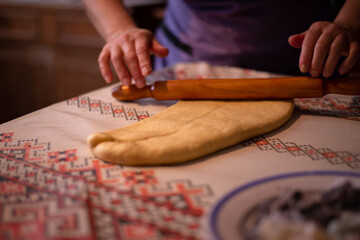 Fototapeta na wymiar the housewife spreading the dough with a rolling pin. preparation of homemade cakes