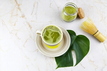 Green tea matcha drink, matcha powder and whisk on a light background. The concept of the Japanese tea ceremony. 