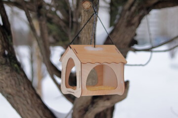 Wooden bird feeder in the trees.