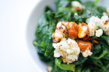 Spinat Salat mit Knoblauch, Chili, Erdnüssen, Sojasoße, Sesamöl, heller Essig, Salz und Pfeffer
