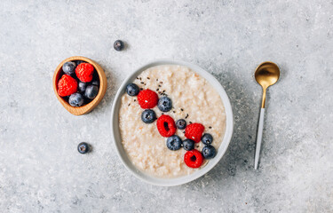 Breakfast oatmeal porridge with fresh berries and almond milk. Healthy vegan food concept