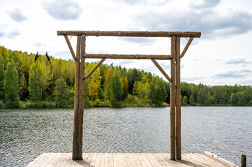 Wooden frame on the plank placing near the lake with picturesque landscape