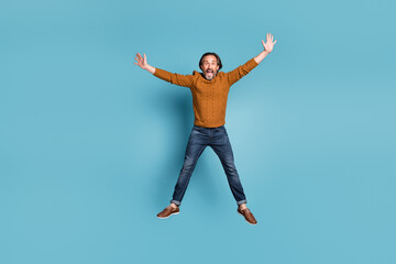 Full size photo of mature happy crazy smiling man jumping in star pose screaming in excitement...