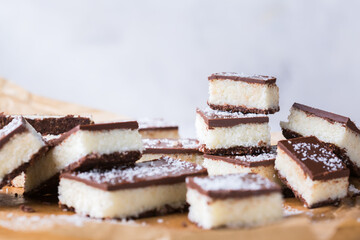 Organic raw vegan coconut bars with chocolate on kitchen table