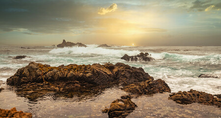 Beautiful seascape, ocean views, rocky coast, sunlight on the horizon. Composition of nature. Sunset scenery background. Cloudy sky. Water Reflection. California Seashore.